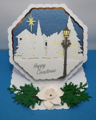 Octagonal easel card with village scene and Christmas rose.