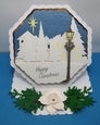 Octagonal easel card with village scene and Christmas rose.