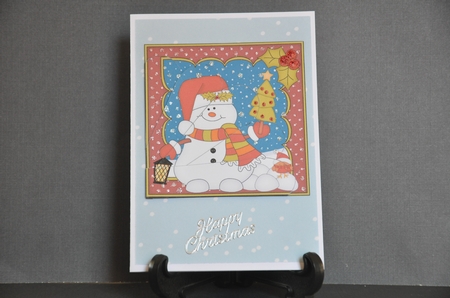 Christmas Snowman Oli has a Christmas Tree Fan Pyramage Topper by Barbara Stubbings