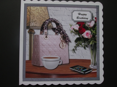 Ladies bag, phone and flowers on table by BELINDA ABRAHAM