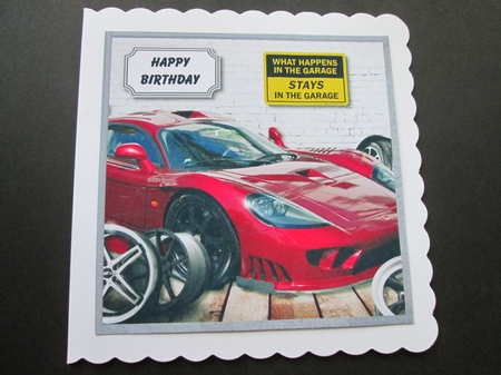 Garage with red high performance car by BELINDA ABRAHAM