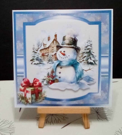 Snowman in the garden with a gift 7x7 by Benita Jenkinson