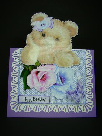 Pretty Flowers with Fuzzy Bear in Bow, Over the Edge by Beverly Carmichael