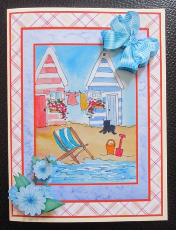 A5 beach scene with beach huts, deckchair, bucket and spade and black cat. Card topper with decoupage by Davina Rundle