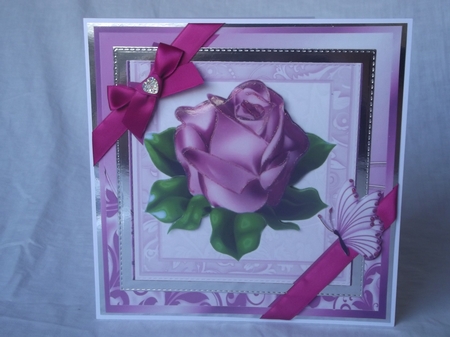 A single pretty pink rose with corner bow in ornate frame 8x8 by Gwyneth Morley