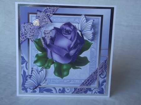 A single pretty purple rose with corner bow in ornate frame 8x8 by Gwyneth Morley