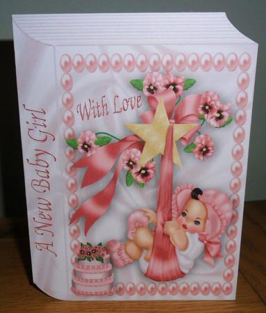 Sweet Baby Girl with Diaper Cake on Folded Book by Johanna Lambert