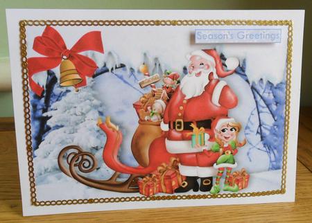 Santa with His Little Elf and Toys in the Snow A4 by Johanna Lambert