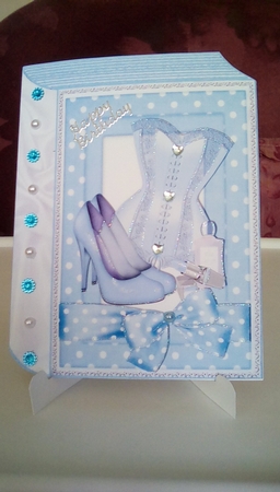 Ladies basque, shoes, makeup in blue polkadot folded book by Joyce Edwards