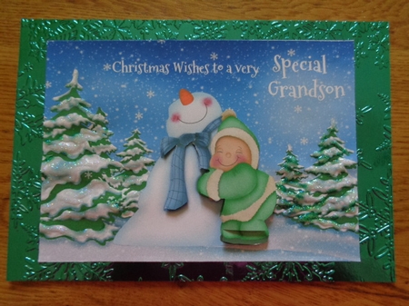 Christmas card for Grandson with child cuddling snowman by Karen Faulds