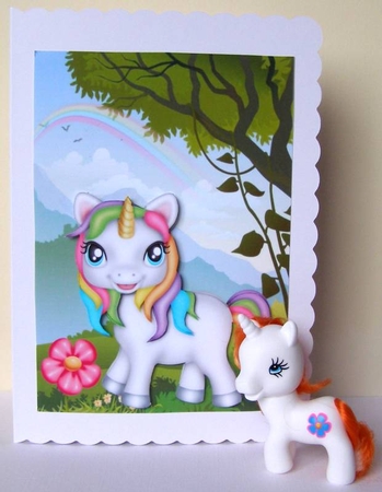 Gorgeous little rainbow unicorn in the meadow with rainbow by Margaret McCartney