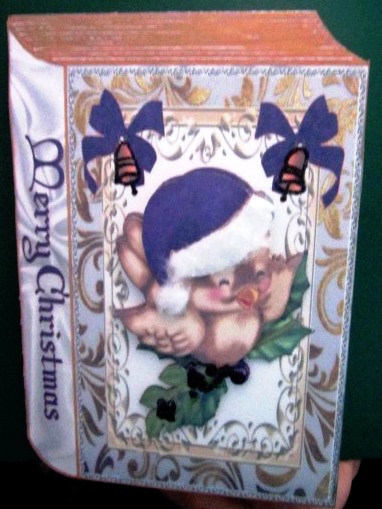 Cute Robin in Purple Santa Hat on Holly Folded Book by Margarette Blakeborough