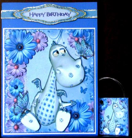 Cute Little Blue Dino with Lilac/blue Flowers & Butterflies by Margarette Blakeborough