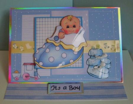 Baby Boy in a Slipper Bed Card Front by Marion MacKellar