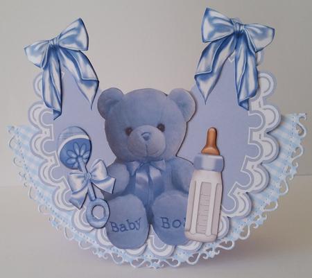 Little Blue Teddy with Bottle and Rattle on Frilly Bib by Mary Brunton