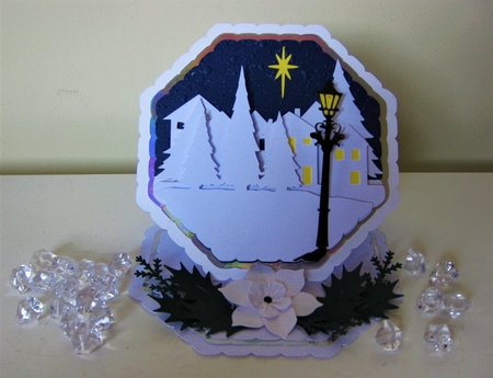 Octagonal easel card with village scene and Christmas rose. by Pat Mottram