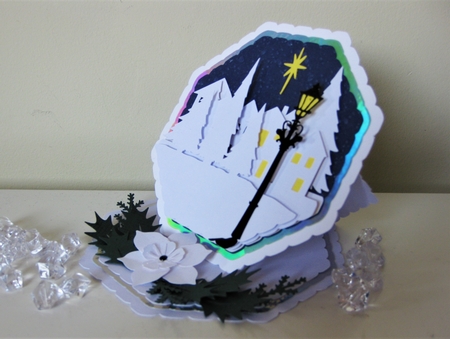 Octagonal easel card with village scene and Christmas rose. by Pat Mottram