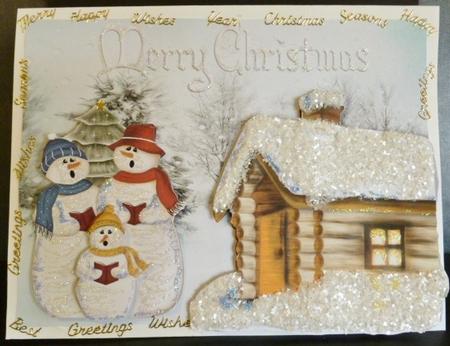 Snowman Family Singing with Cottage by Susan Powell-Barton