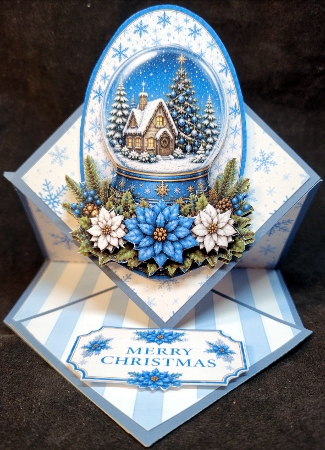 Blue Snow Globe Cottage Topper – Cozy Winter Scene with Merry Christmas Label by Susan Mehlbaum