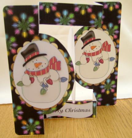 Snowman with Fairy Lights Oval Pop Out by Valerie Cuthbertson