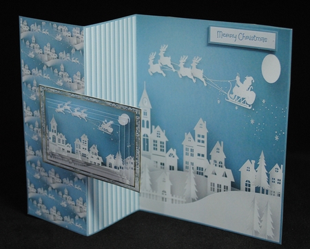 Santa in flight over the town by Yvonne Middleton