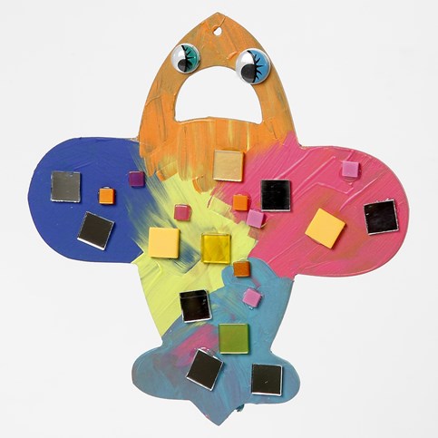 A flat wooden decorative Shape – painted and decorated with Mosaics